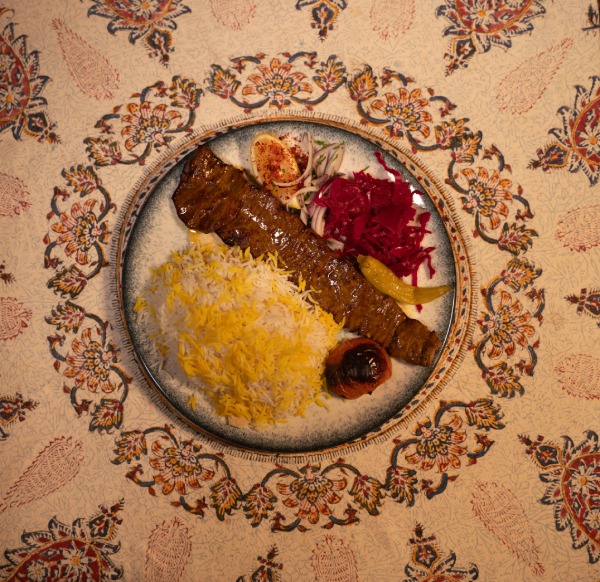 Koobideh kebab, saffron basmati rice, grilled tomato, and pickled red cabbage in Soofi restaurant